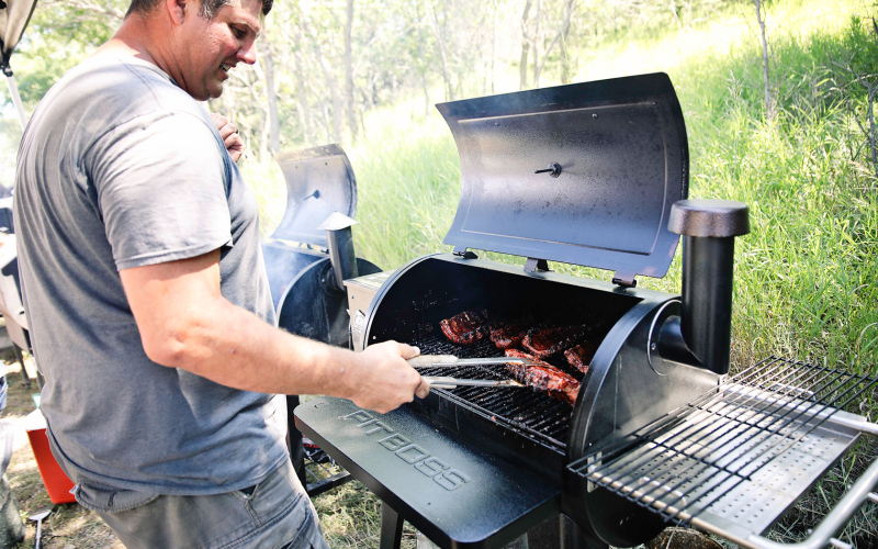 Craig Heumiller flips several racks of ribs during competition.
