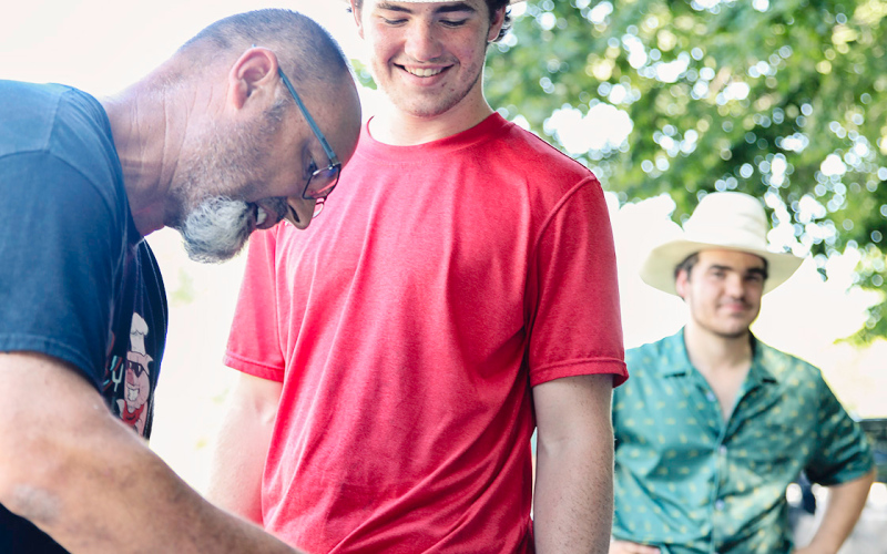 Gene Gaikowski processes his racks of ribs with sons Nathan and Carter looking on.