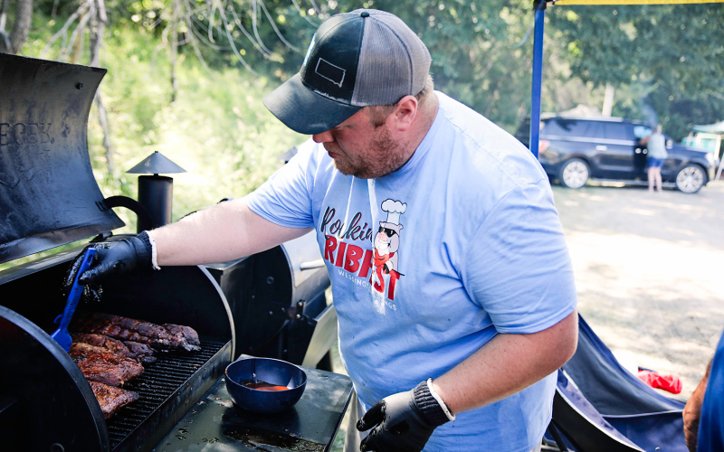 Blake Willman applies more sauce during the smoking process.