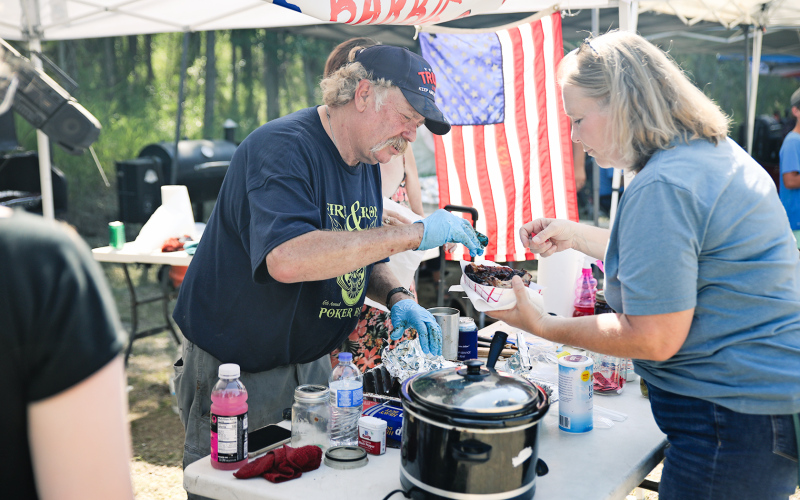 Rosie Jensen tries ribs from Mike and barbie Brunsen.