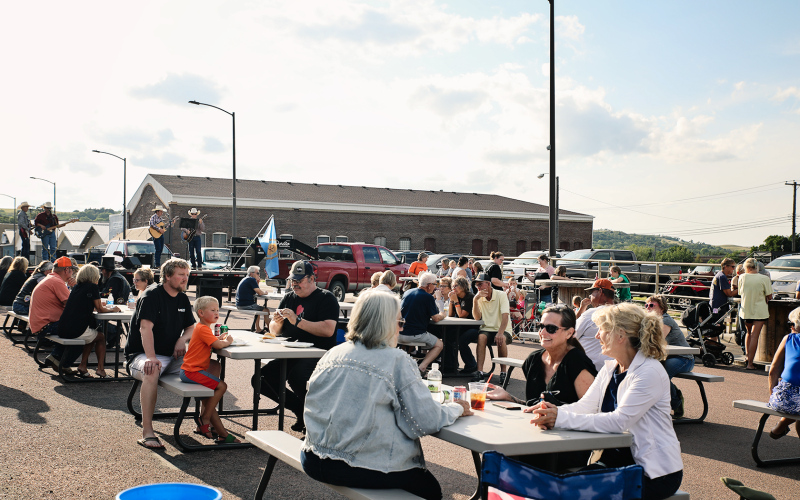 A large crowd gathered on Main Street in front of Pin Twisters following the Sons of American Legion Poker Run for a community supper and live musical entertainment Saturday.