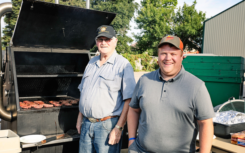 Verle Hoffman and Blake Willman pause for a photo before getting back to grilling what Hoffman described as “full of flavor” burgers.