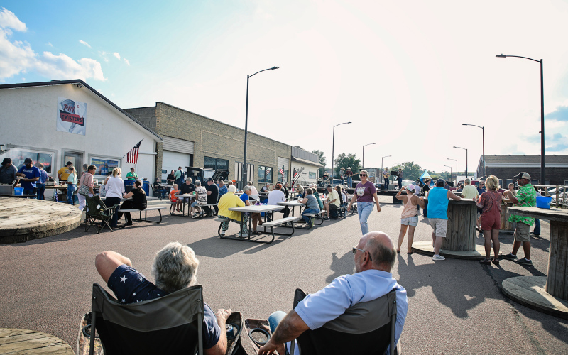 A large crowd gathered on Main Street in front of Pin Twisters following the Sons of American Legion Poker Run for a community supper and live musical entertainment Saturday.