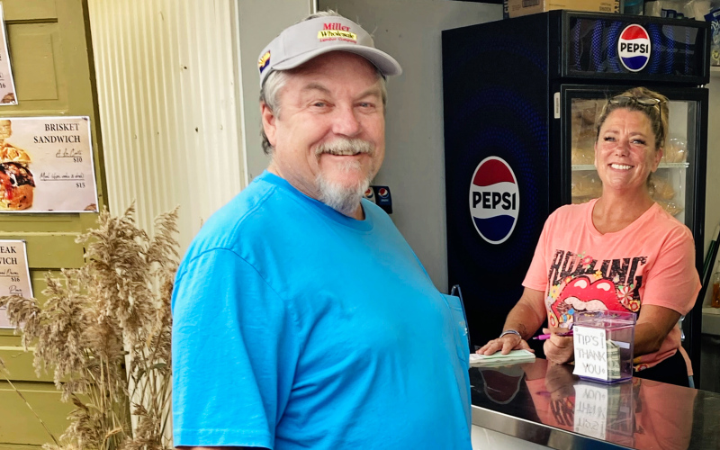Glenn Miller of Mesa, AZ orders a brisket sandwich from Wessington Springs woman Robin Berens at the Sweet Grass booth. DELIA ATKINSON / TRUE DAKOTAN