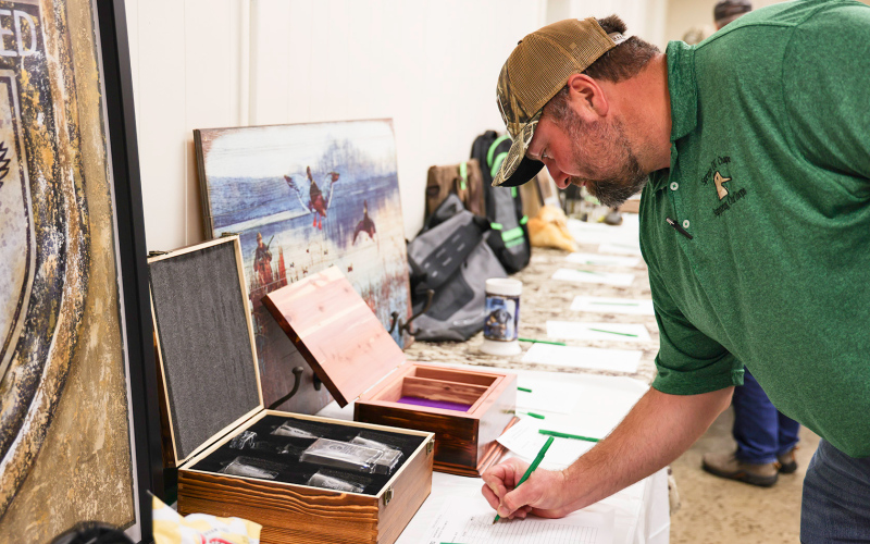 Ducks Unlimited member Scott Miller checks his bid on the silent auction.