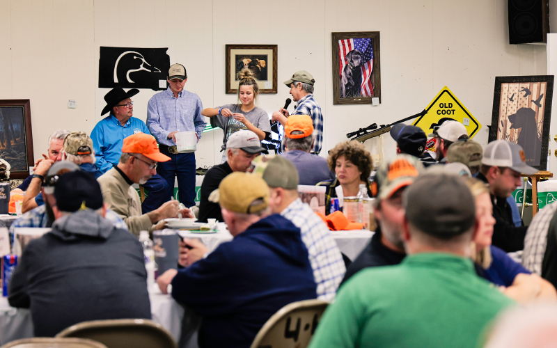 Auctioneers Val Luckett and Clayton Keck get a hand from Jada Kolousek and emcee Tom Mebius during the live auction held at the Ducks Unlimited Banquet Saturday.