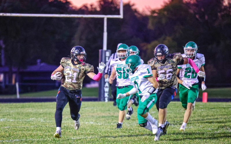 Payton Uecker (21) runs the ball down the field with the help from Robert Hine (56).