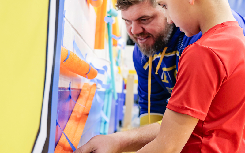 During the educational event aimed at fostering family engagement in learning, Cody Hasty and son Miles work on the “marble wall.”