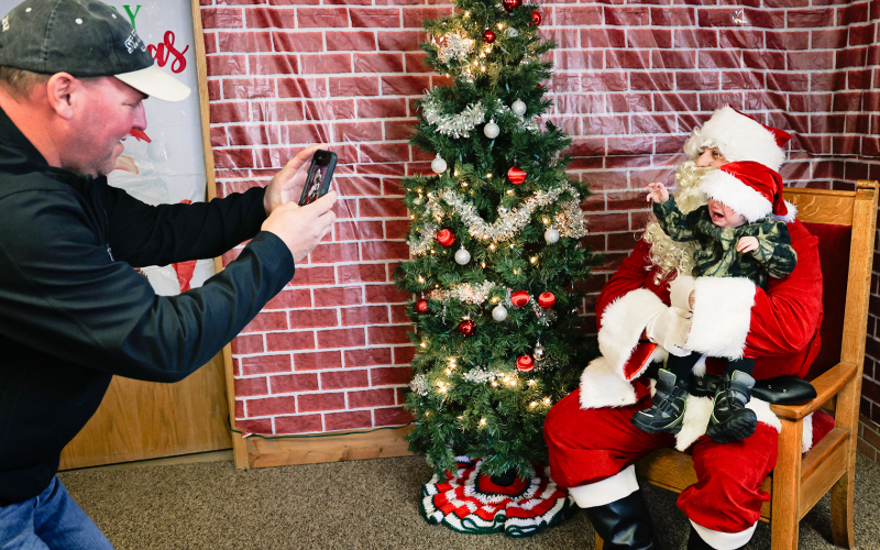 Jolly Old St. Nick made his annual stop during Santa Saturday on December 21, 2024. Pictured at City Hall in Wessington Springs is Michial Brodkorb of Wessington Springs, snapping a quick photo of his grandson Tyson Johnson, who was less than thrilled to meet Santa for the first time.