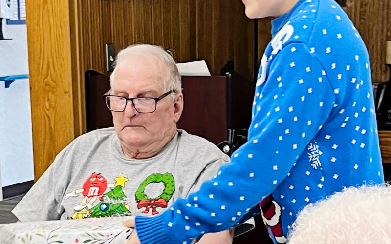 WSHS student Kennedy Kolousek delivers a gift to Weskota Manor Avera resident Les Caffee as part of her angel tree senior project. PHOTO COURTESY LIZA KOLOUSEK