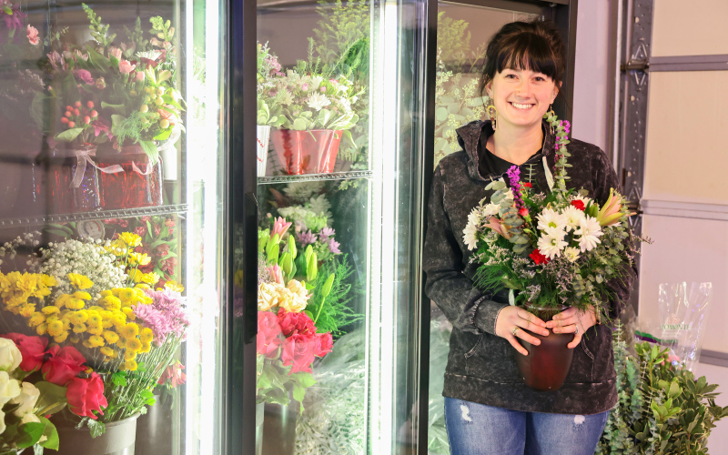 Owner of 2nd and Bloom, Bethany Schimke, holds a Valentine’s Day bouquet on February 10, 2025 in front of a newly-purchased flower cooler. KRISTI HINE / TRUE DAKOTAN