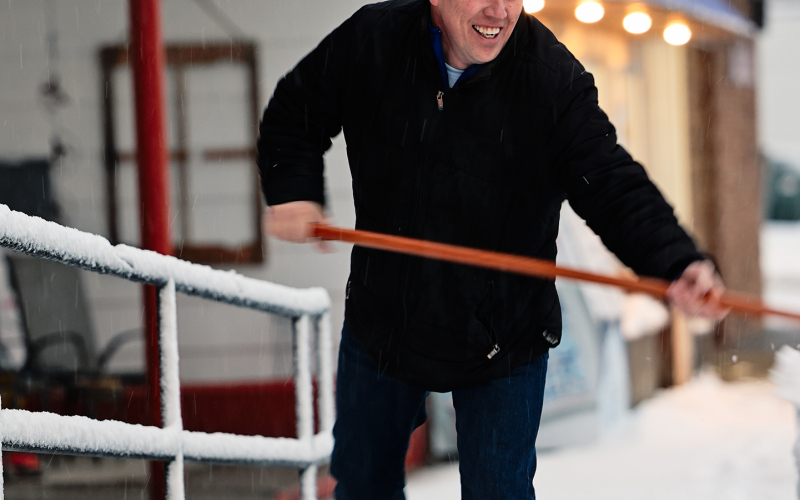 Springs Food Market owner Ryan Jensen scoops the sidewalk on Main Street Tuesday morning.