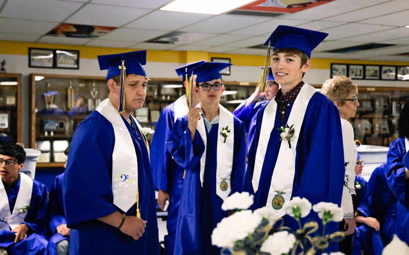 Landen Christensen flashes a big smile as he and classmates Will Bruckner and Ranick Fjertstad wait for the ceremony to begin.