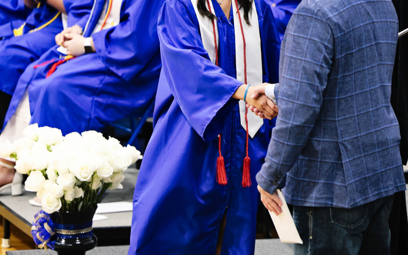 Mariah Messmer shakes school board chair Dustin Weber’s hand before accepting her diploma.