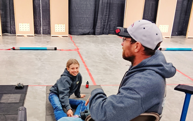 With her Dad and coach Jared spotting with his binoculars, Crawleigh Reiner smiles after a personal best in BB Gun at the State 4-H Shoot in Ft. Pierre, SD. COURTESY PHOTO