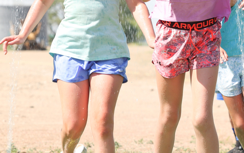 Hadley Weber and Hayden Bultsma cooled off in the sprinkler station at Leap to Lane Saturday afternoon.