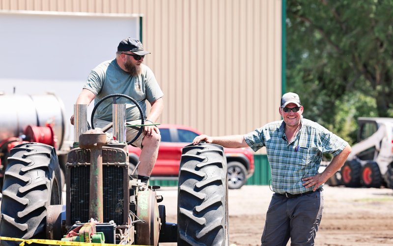 Event organizer Chris Albrecht (right) shares a laugh with one of the tractor pull event contestants.