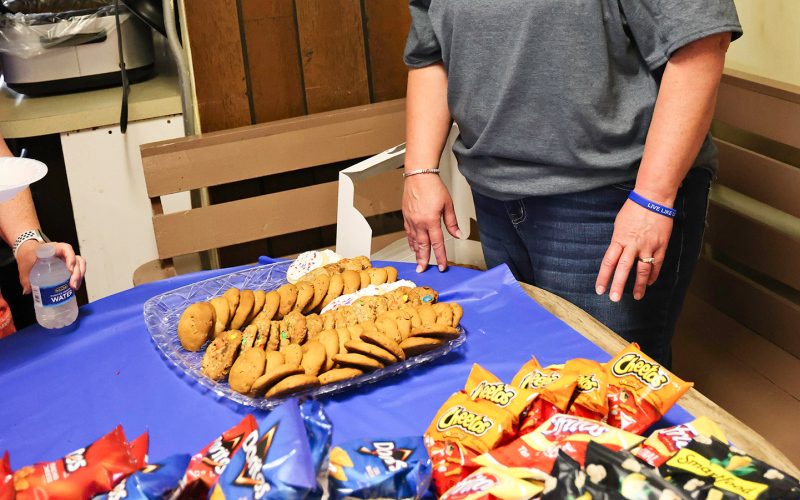 Linda Willman, Teresa and Craig Fonder dish up pulled pork sandwiches accompanied by chips and cookies, served up by Melanie Schelske.