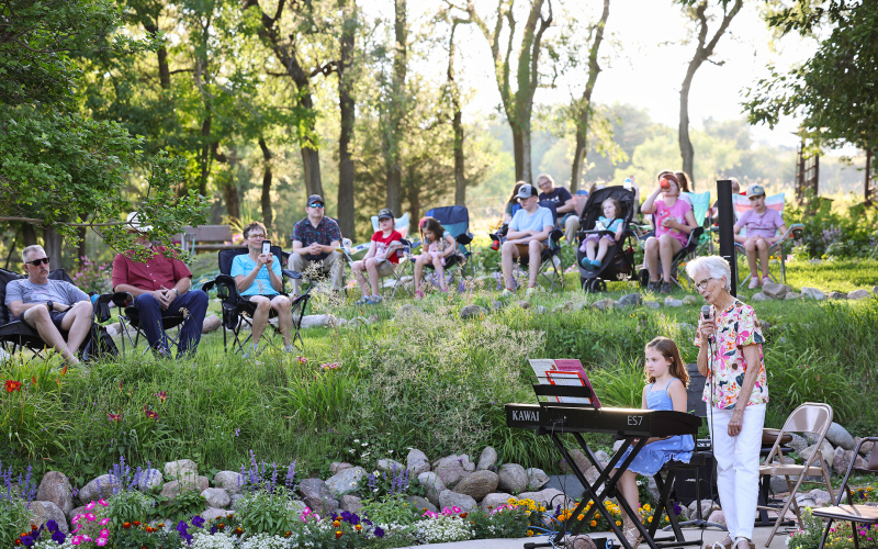 Lois Feistner introduces one of the performers, Emmie Bartel during the July 24, 2025 Music in the Garden.