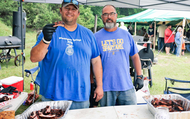 Rockin Ribfest contestants Brady Duxbury and Gene Gaikowski take a break from serving up ribs to smile for a photo.