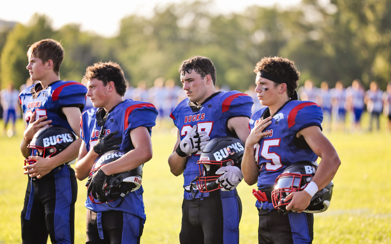 Bucks salute the flag during the Pledge of Allegiance. Shown left to right are Ethan Amick, Damien Knippling, Nathan Gaikowski and Hayes Havlik.
