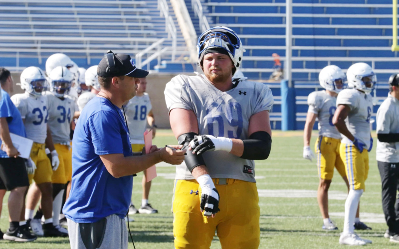 Offensive lineman Quinten Christensen talks with head coach Dan Jackson during South Dakota State football practice on Tuesday, Aug. 12, 2025 at Dykhouse Stadium in Brookin