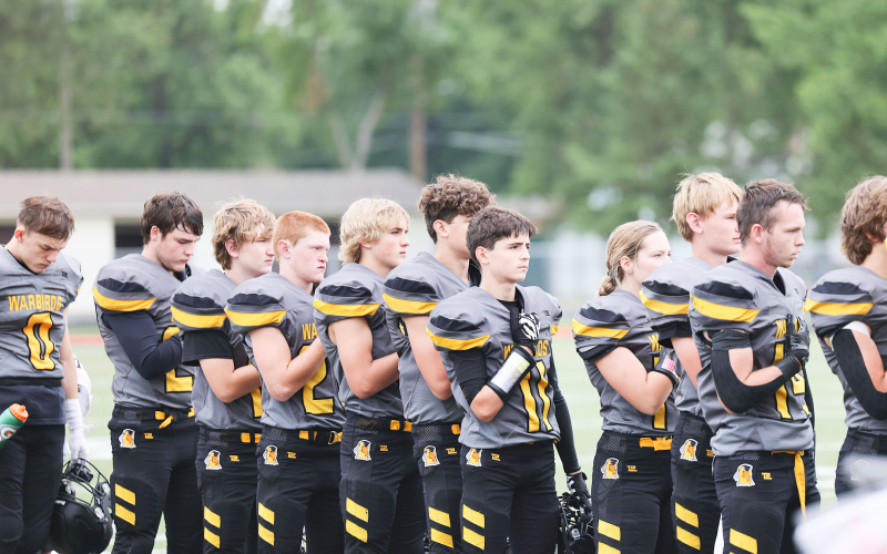 Warbirds salute the flag before kickoff.