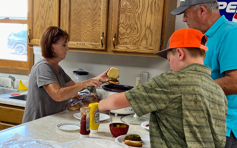 Volunteer Becky Thompson serves up lunch for hungry young golfers following the tournament finale of the youth golf clinics. Thompson and fellow organizer Gloria Vavra led the two-session summer program that emphasized courtesy, confidence, and fun on the course.