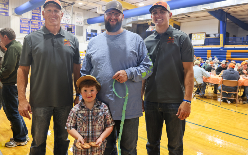 Pheasants Forever volunteers Mike and Brock Krueger shown with banquet attendees Pat and Wade Wetzel.