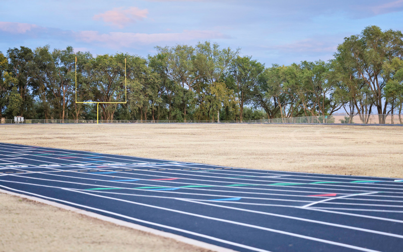 The newly completed Wolsey-Wessington School District track and football complex glows at dusk following the board of education meeting held on Monday, Oct. 13, 2025. The finished project is part of a multi-phase capital improvement plan, which also included a new elementary playground installed before the start of the school year. Next up for the district are plans for a new crow’s nest, bleachers and concession stand at the site. (KRISTI HINE / TRUE DAKOTAN )