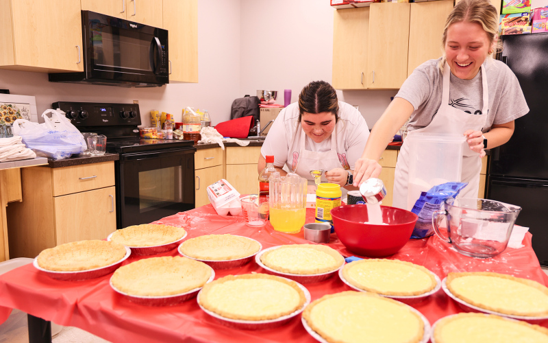 As area families sit down to enjoy their Thanksgiving meal together this Thursday, chances are they’ll be savoring a pie made by Wessington Springs High School (WSHS) students, as part of a long-standing local tradition. Pictured hard at work Tuesday during the annual service-oriented pie baking project are Tierney Knipfer and Kendall Kolousek, separating egg whites and measuring out sugar.