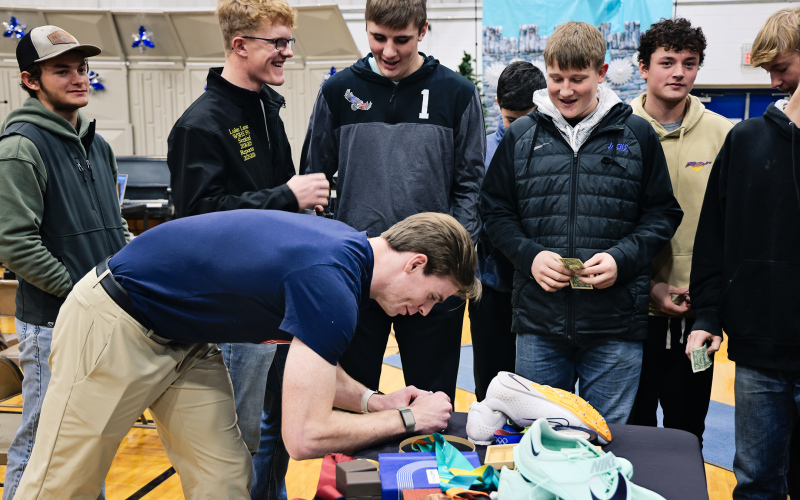Olympic pole vaulter Chris Nilsen signs autographs for Wessington Springs students following the Dec. 4 assembly. Nilsen, the American indoor record holder, spoke about how proper nutrition, including beef — helped elevate his career and support long-term health.
