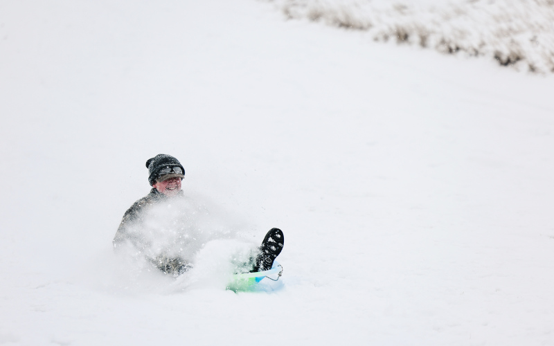 Dawson Bultsma smiles as he flies down the sledding hill Sunday.