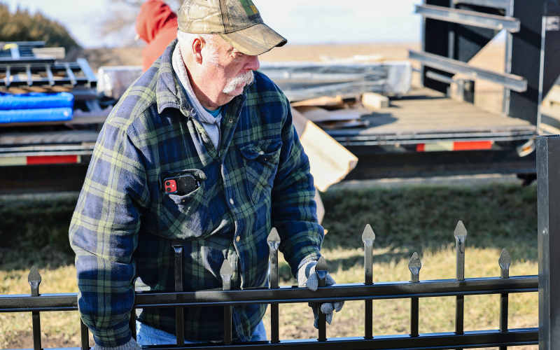 Darrell Deneke and other volunteers with the Hope Cemetery Association work together to install a new perimeter fence at Hope Cemetery.