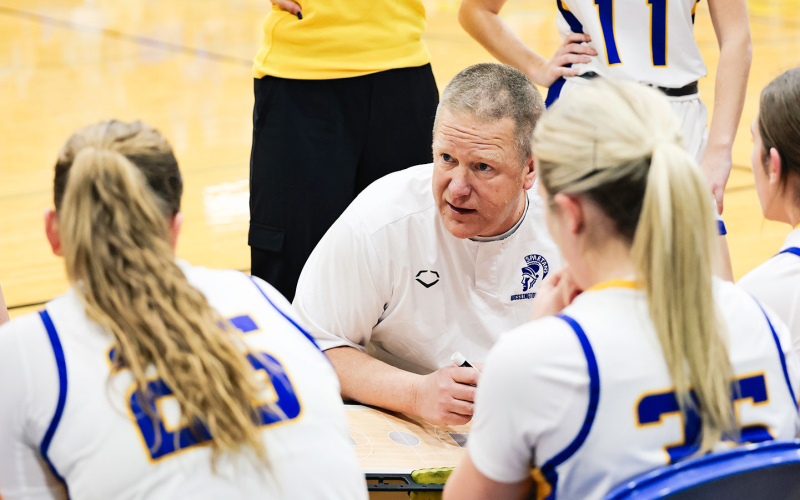 Coach Kolousek and Coach Mikkelson huddle with the team.