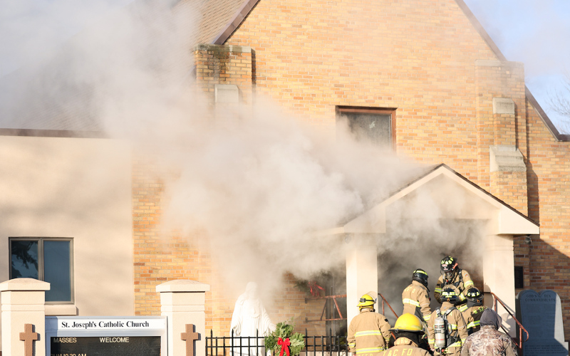 Smoke billows from the front entrance of St. Joseph Catholic Church in Wessington Springs Friday morning as firefighters work at the scene after a fire was reported shortly after 9 a.m. (KRISTI HINE / TRUE DAKOTAN)