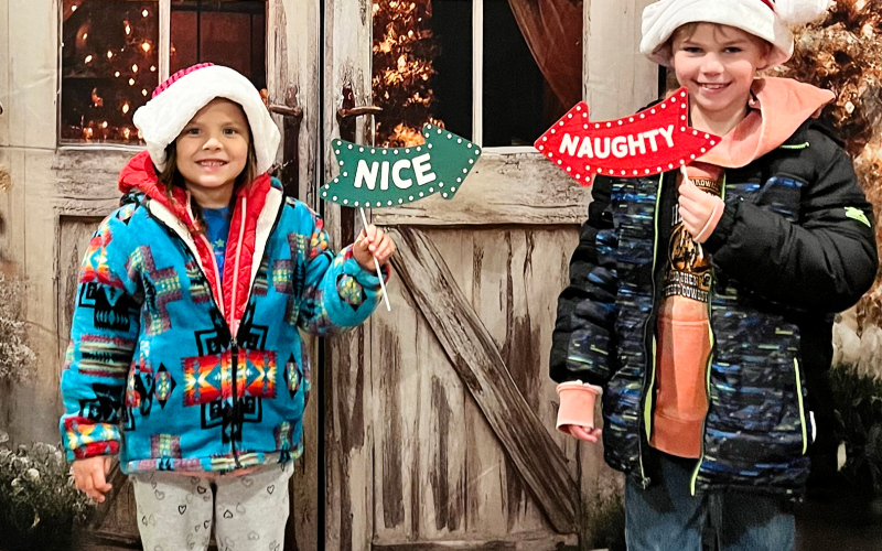 Moxee Mitchell and Kactus Coleman strike poses with the “naughty or nice” photo booth props at the True Dakotan (PHOTO COURTESY BECKY KRUEGER)