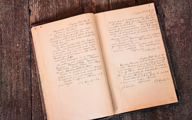 An original Hope Cemetery record book’s carefully preserved pages documents the cemetery’s founding, early membership rolls, land transactions, and handwritten notes dating back to the late 19th century.