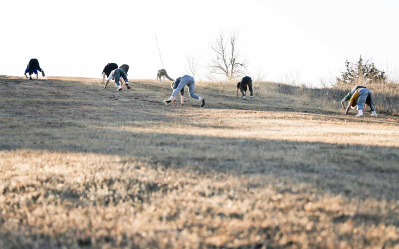 Warhawk wrestlers make their way down the ski hill in a reverse bear crawl during an outdoor conditioning session last week, part of their preparation for the upcoming region tournament.