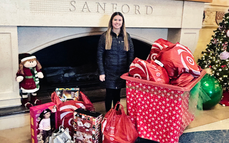 Wessington Springs High School senior Jada Kolousek poses with a pile of gifts donated to Sanford Children’s Hospital in Sioux Falls, a project inspired by her late classmate Estrellita Cardona. (COURTESY PHOTO)