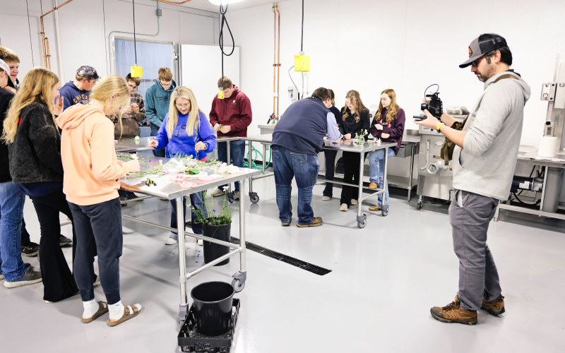 Filmmaker Zeke Hanson captures footage of a floriculture activity led by Ranchy Stem’s Katie Jones inside the new agriculture lab at Wessington Springs High School as part of a documentary on 100 years of FFA in South Dakota. (KRISTI HINE / TRUE DAKOTAN)