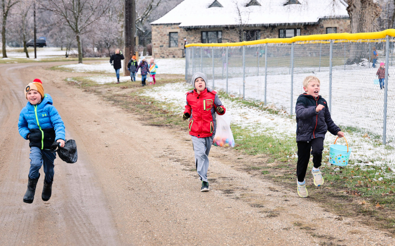 Tripp Olinger, Drew Duxbury and Brecken Jensen charge down the path eastward from the Fieldhouse in search of more eggs.