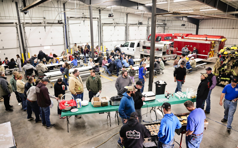 An aerial view of the fire hall captures the full scene, with firefighters and auxiliary members busy keeping up with a line out the door, while kids pose for photos with the Easter Bunny and the community settles in for food and fellowship.