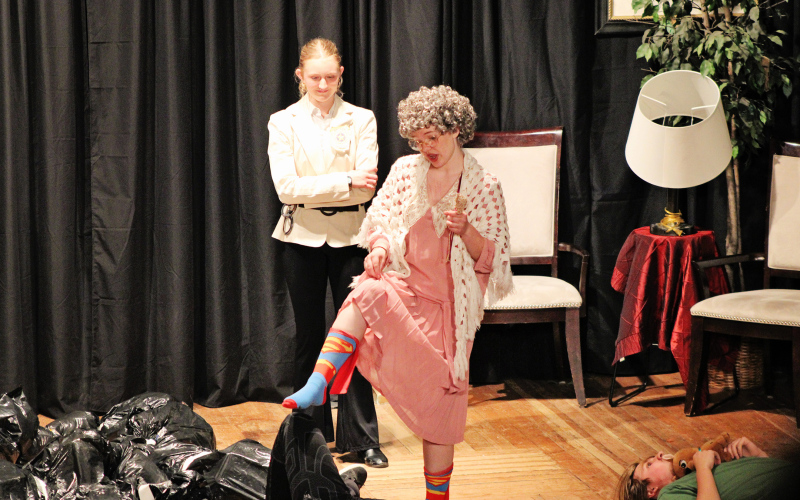 Alexis Roesler (Detective Christie) looks on as Madilyn Gaikowski (Miss Marple) checks for signs of life with a curious nudge during WSHS’s comedic mystery, Too Many Detectives at the Murder Mansion.