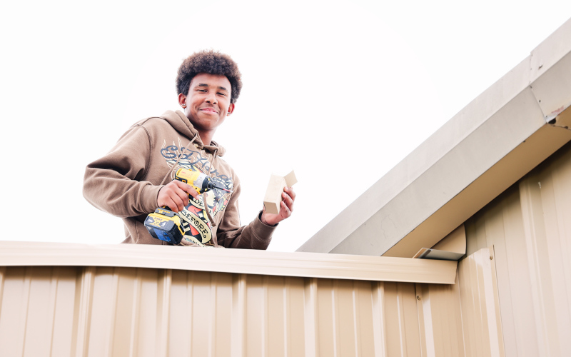 Demone Odum works on the roof during the final phase of the greenhouse project.