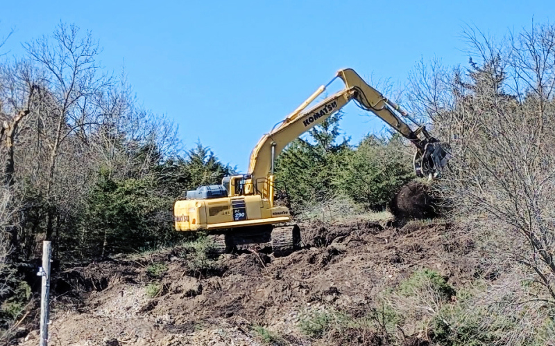 Crews with Feistner Gravel and Excavation use an excavator to clear trees along a steep hillside southwest of City Park for the Mid-Dakota Rural Water connection project.  (MIKE MEBIUS / TRUE DAKOTAN)