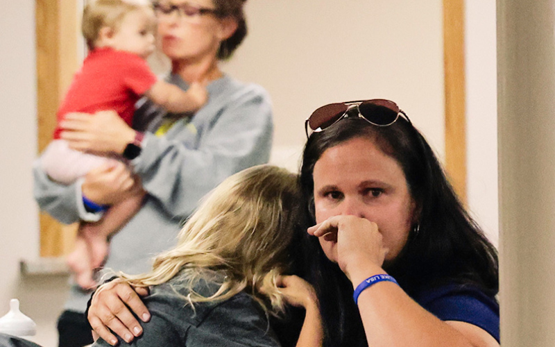Erin Yost fights back tears as her daughter, Gentry, cries in her lap following the announcement that St. Joseph Catholic Church in Wessington Springs will not be rebuilt after being damaged by fire in December.