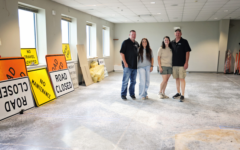 From left, Michael and Jen Feistner and Jennifer and Brian Feistner stand inside the former American Legion building, which the family recently purchased for Feistner Excavation and Gravel. Road closed and no maintenance signs are among the first job materials moved into the building, where work has begun on a large overhead door on the north side for storage access. Construction of office space is planned for this fall. (KRISTI HINE / TRUE DAKOTAN)