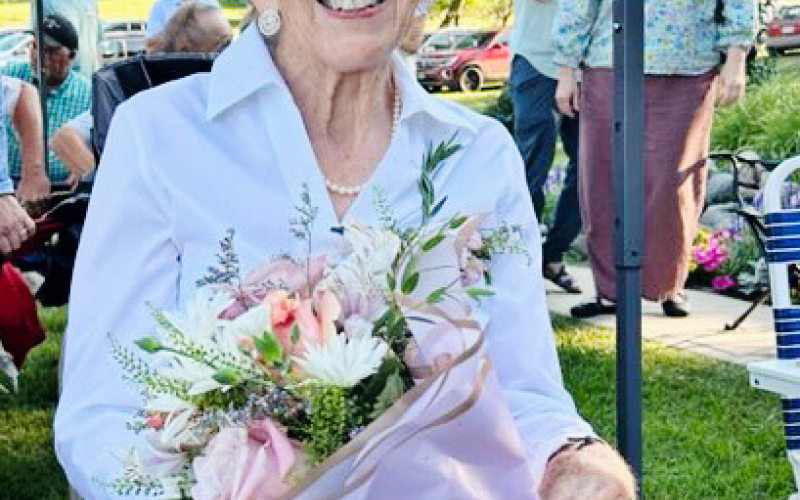 Kathy Dean holds flowers presented in recognition of her 37 years of dedication to the Shakespeare Garden Society. (PHOTO COURTESY GWYNETH FASTNACHT)