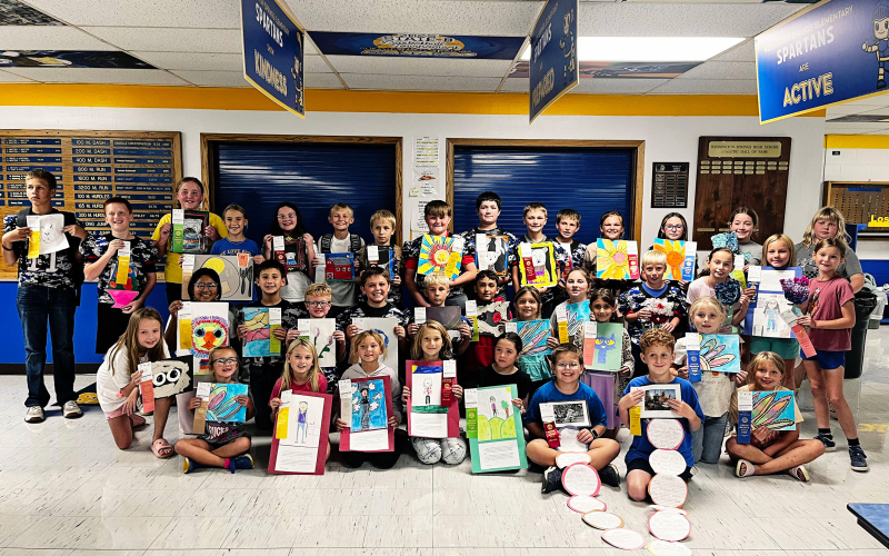 CLEANING HOUSE AT THE STATE FAIR. More than 30 Wessington Springs Elementary students in grades K-6 proudly show off the artwork and ribbons they earned at the South Dakota State Fair. The young artists gathered in the elementary lunchroom for a group photo celebrating an impressive showing at this year’s fair. (PHOTO COURTESY LEXI JOHNSEN)
